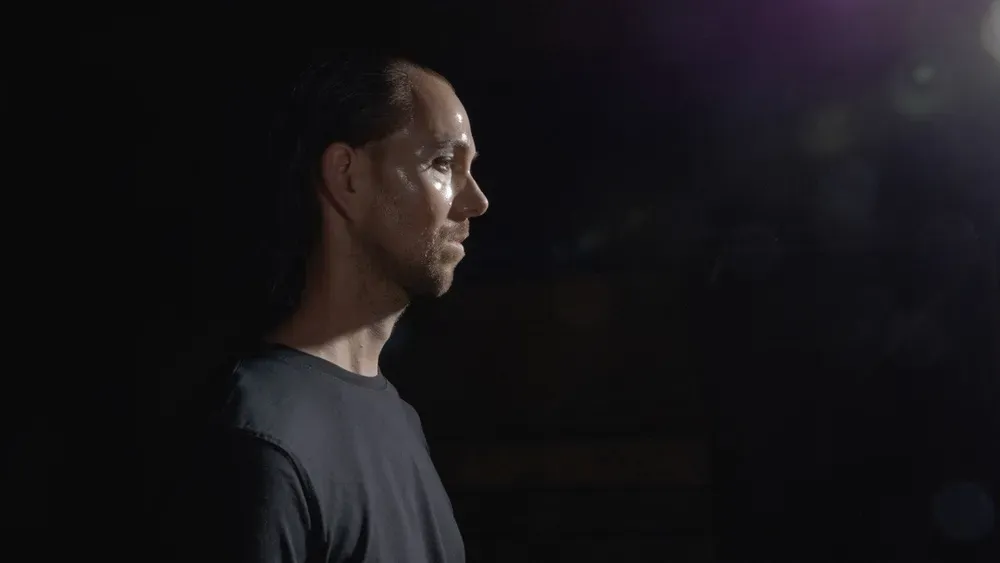 Maik im Seitenprofil vor dunklem Hintergrund.